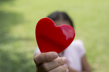 Fototapeta na wymiar Girl holding a heart toy