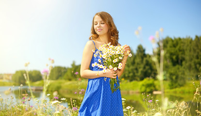 Beautiful girl with bunch of camomiles