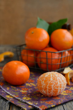 Ripe tangerine fruit and wire basket full of mandarines