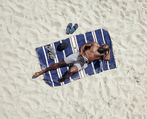 African guy relaxing on beach holiday