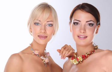 Portrait of a two beautiful women with necklace, isolated on