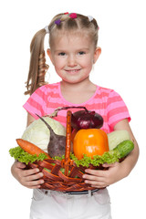 Little girl holds a basket with vegetables