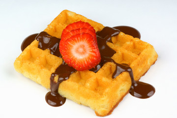 Waffle with strawberry slices and chocolate sauce