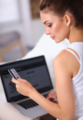 Woman shopping online with credit card and computer.