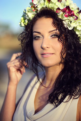 Naklejka premium Pretty young girl in a wreath of flowers
