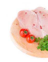 Raw chicken breast on wooden platter.