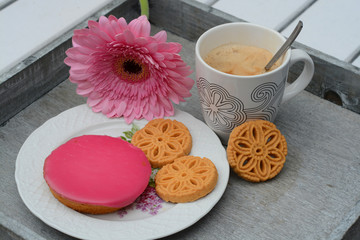 Koffie met koekjes met roze gerbera