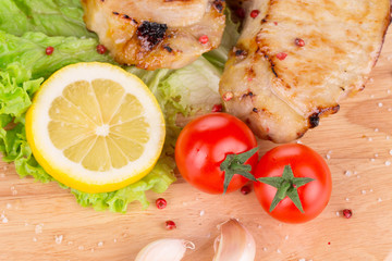 Grilled meat on wooden platter.