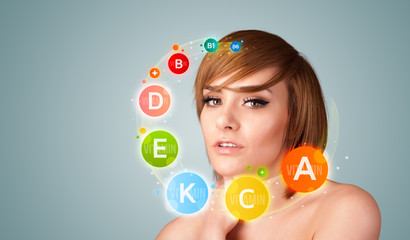Pretty young girl with colorful vitamin icons and symbols