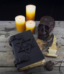 Magic still life with skull, book and candles