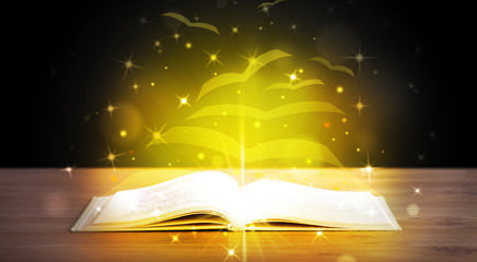 Open book with golden glow flying paper pages