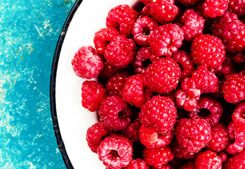 Raspberries in a bowl on rustic wooden background