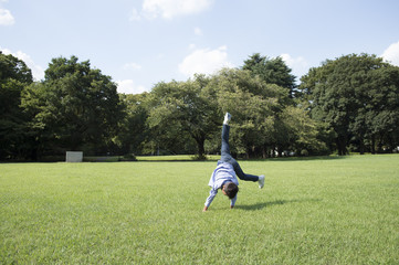 Boy to a cartwheel in grassland