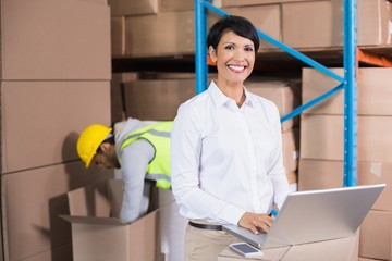 Pretty warehouse manager using laptop