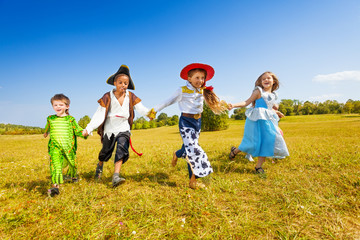 Happy kids run wearing costumes in park
