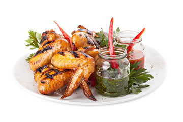 Plate of grilled chicken wings with sauce.