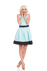 Excited blonde girl in pastel blue dress