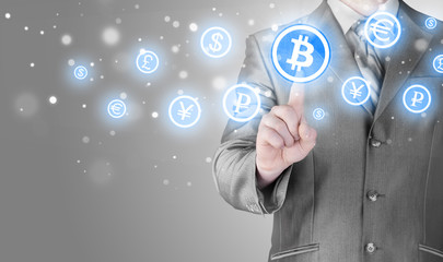 Choosing bitcoins, businessman pressing touch screen button.