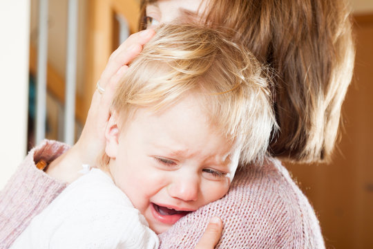 Mom holding  crying child