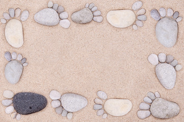Fototapeta na wymiar pair feet made of a stone on the sea sand