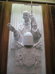 Busto a rilievo di papa san Paolo VI che regge la croce e benedice i fedeli all'uscita dalla Sala...