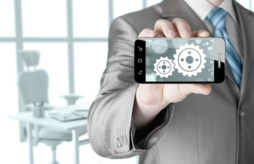 businessman show gear on smartphone to success concept