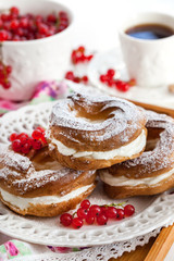 Cream puff rings decorated with fresh red currant