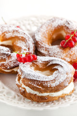 Obraz na płótnie Canvas Cream puff rings decorated with fresh red currant