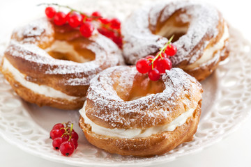 Obraz na płótnie Canvas Cream puff rings decorated with fresh red currant