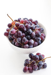 Dark grape in a bowl on white