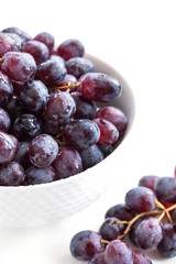 Dark grape in a bowl on white