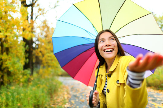 Autumn / fall woman happy in rain with umbrella