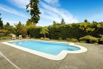 Swimming pool with deck chairs