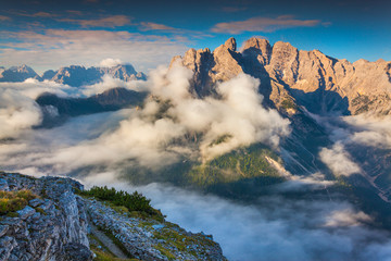 Gruppo Del Cristallo mountain range at foggy summer morning. Dol
