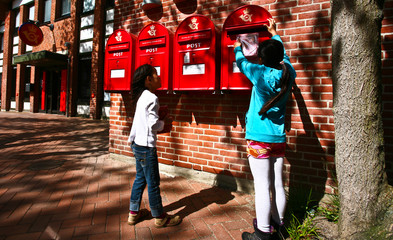 girl dropping a letter in a red postbox in denmark