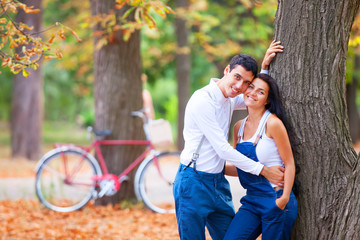 Obraz na płótnie Canvas Teen couple with bike in the park in autumn time