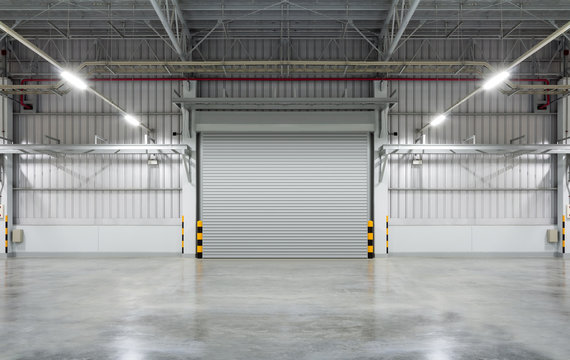 Factory, warehouse or industrial building. Protection with security door, roller door or roller shutter. Modern interior design with concrete floor, steel wall and empty space for industry background.
