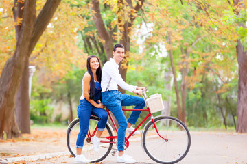 Teen couple with bike in the park in autumn time