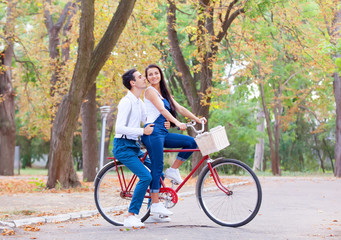 Teen couple with bike in the park in autumn time