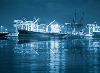 Gantry crane loading and unloading cargo container  from cargo ship at port to show global...
