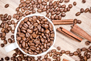 White coffee mug filled with coffee seeds.