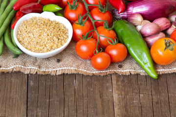 Raw Organic bulgur in bowl and vegetables