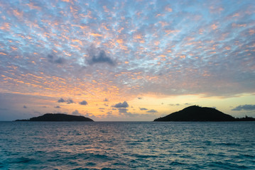 Naklejka na ściany i meble Scenic view of sunset with clouds and two Seychelles islands