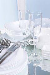 Set of white dishes on table on light background