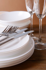 Set of white dishes on table on brown background