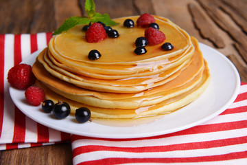 Sweet pancakes with berries on table close-up