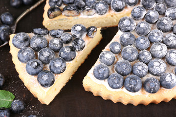 Tasty homemade pie with blueberries on wooden table