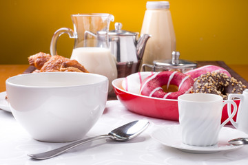 Prima colazione con donuts, brioches, latte e caffè