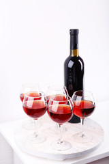 Glasses and wine bottle on tray in room