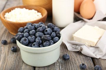 Fresh blueberries and milk products on wooden table